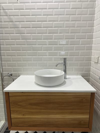 Plumber replacing a mixer tap cartridge at a bathroom basin